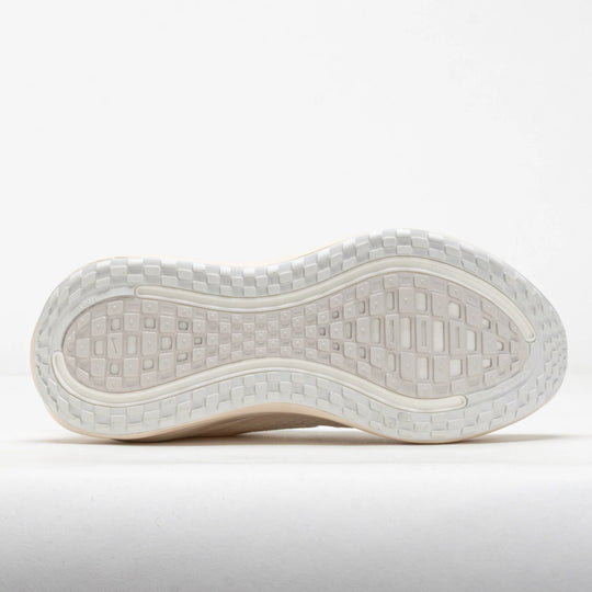 The outsole of a white athletic shoe, showing a textured tread pattern and a flexible white midsole, photographed against a clean white background.