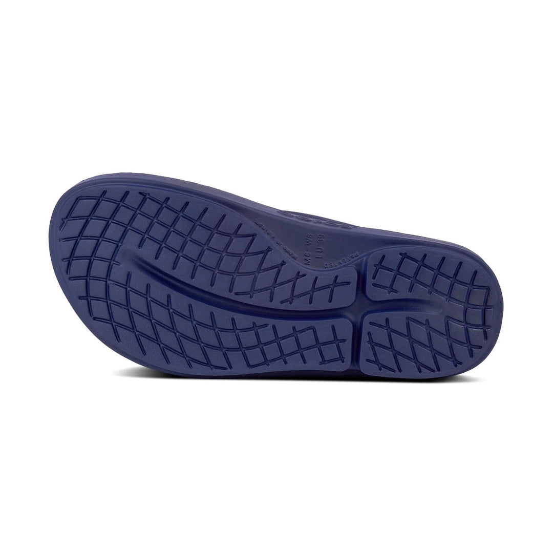 A close-up of a dark navy blue shoe sole with a textured grid tread pattern, shown against a plain white background.