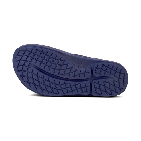 A close-up of a dark navy blue shoe sole with a textured grid tread pattern, shown against a plain white background.