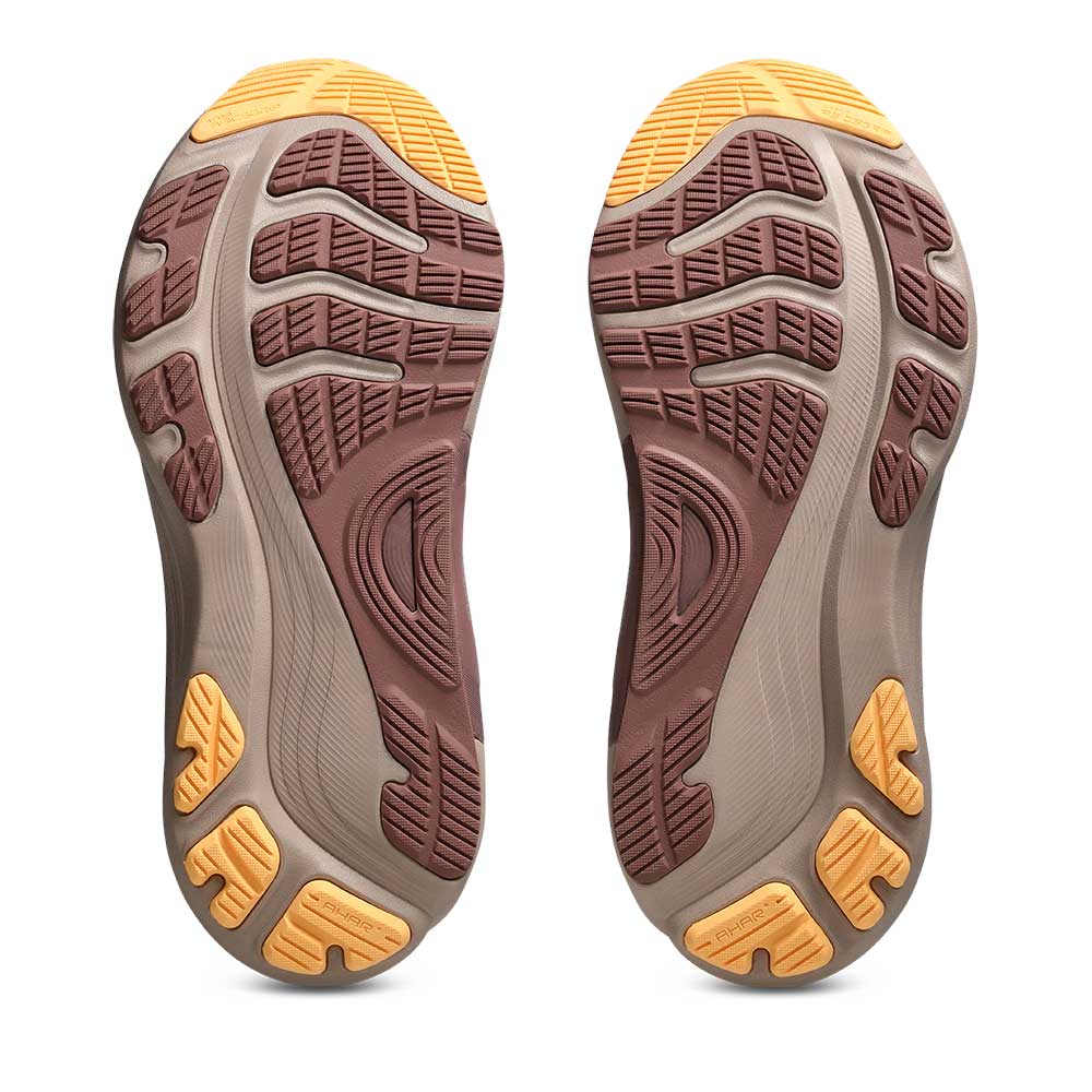 A pair of Gel-Kayano 32 shoe soles shown from the bottom, featuring a brown and gray tread pattern with bright yellow accents on a white background.