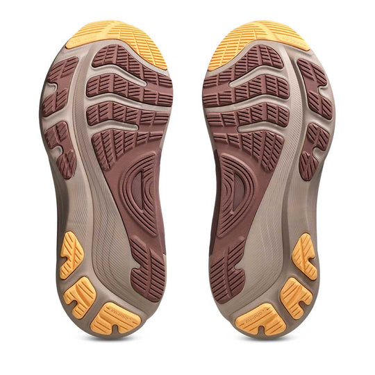 A pair of Gel-Kayano 32 shoe soles shown from the bottom, featuring a brown and gray tread pattern with bright yellow accents on a white background.