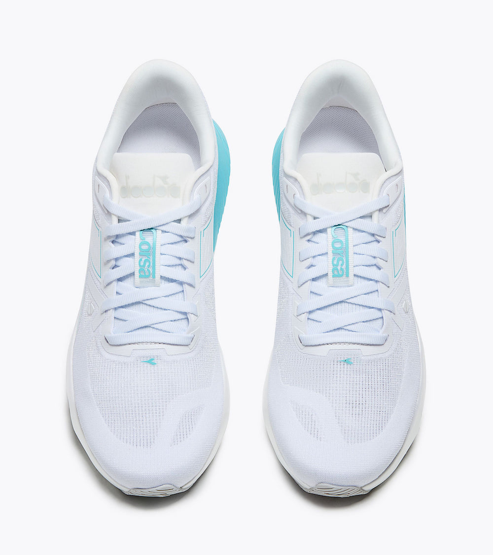 A pair of white Corsa - Women's running shoes with light blue laces and turquoise accents, shown from a top-down view on a light gray background.