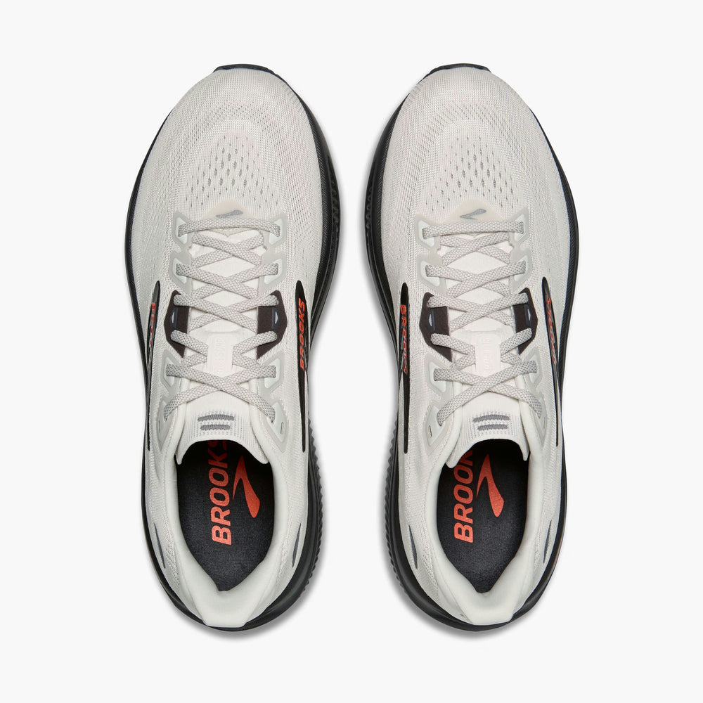 A pair of Brooks Men's Ghost 18 running shoes shown from a top-down view on a light gray background. The shoes are primarily white with black midsoles and heel accents, and feature orange branding on the tongue and heel insert.