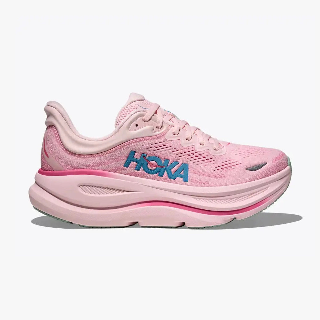 A pink HHoka Bondi 9 – Women's running shoe shown from the side against a light gray background. The shoe features a pink mesh upper, a thick pink cushioned sole, and a prominent blue 'HOKA' logo on the side.