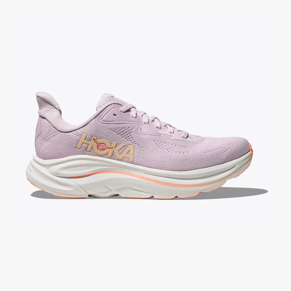 A single Hoka Clifton 10 – Women's running shoe in light lavender pink, featuring a chunky white midsole with a thin orange accent line and a metallic gold HOKA logo on the side, set against a clean white background.