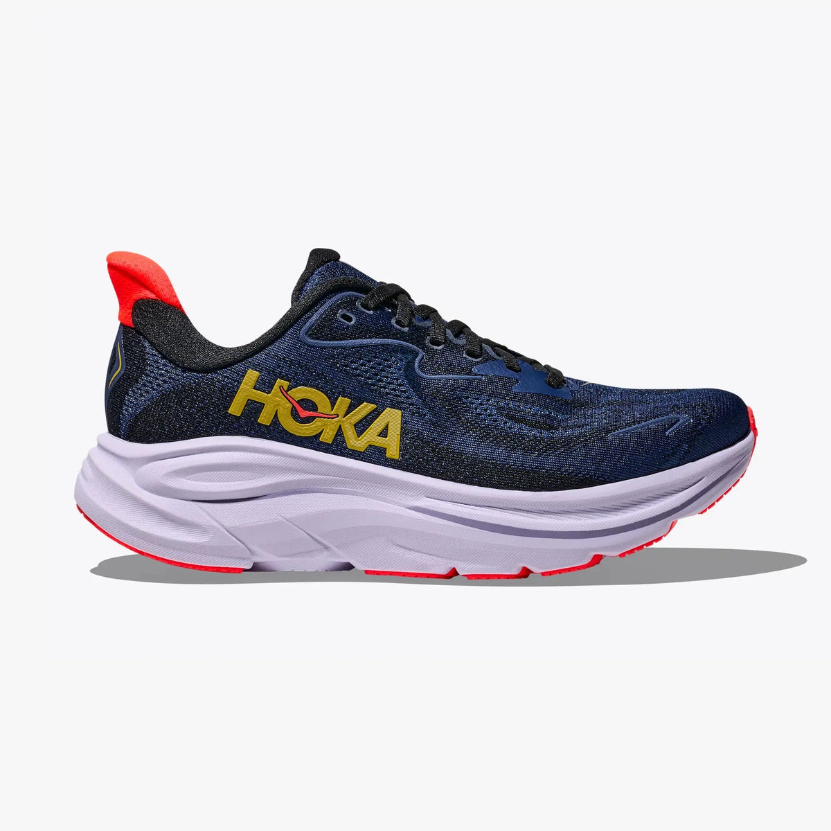 A Hoka Clifton 10 – Women's running shoe in navy blue with a thick white midsole and bright red accents on the heel, toe, and outsole, featuring a yellow Hoka logo on the side.