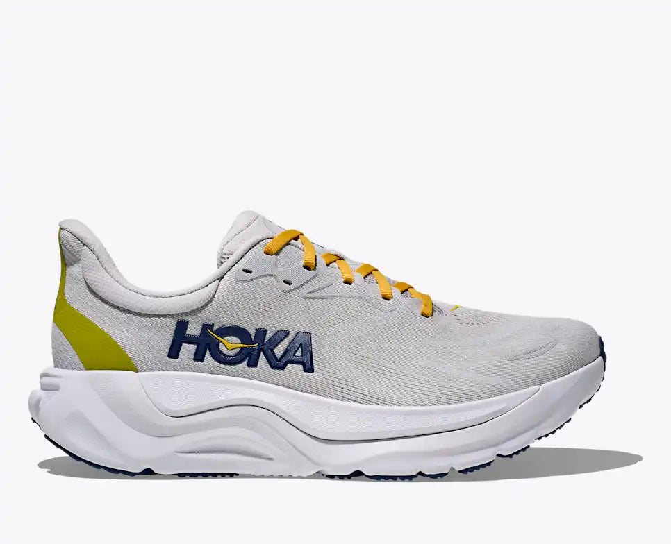 Gray running shoe with yellow accents and 'Hoka' branding on a white background