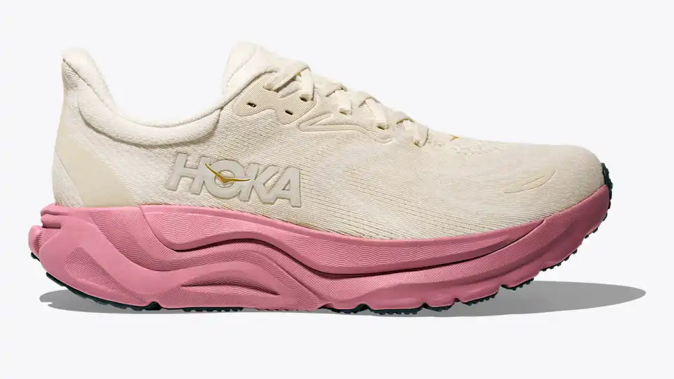 White running shoe with pink sole on a white background