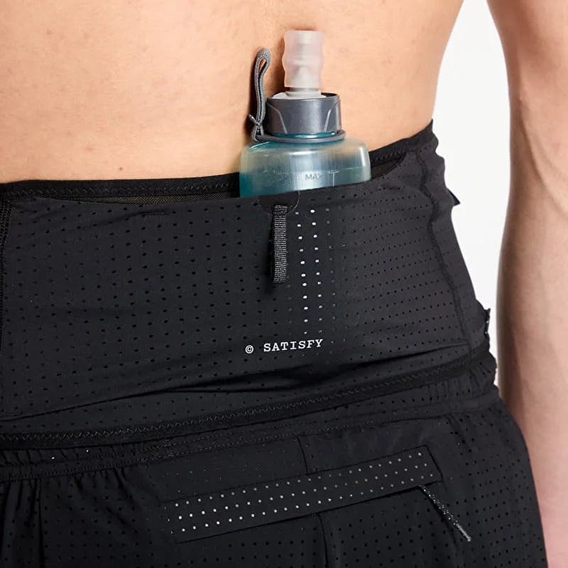 Close-up of a black perforated Space-O Belt--All Gender worn by a model, with a translucent blue water bottle tucked into the front pocket. The brand name &