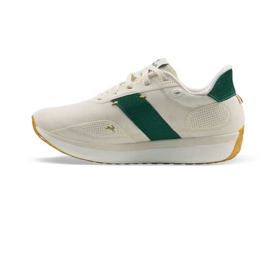 A Tracksmith Eliot Ryder – All Gender sneaker in off-white with a dark green side stripe, a green heel tab, and a gold Puma cat logo on the side, set against a plain white background.