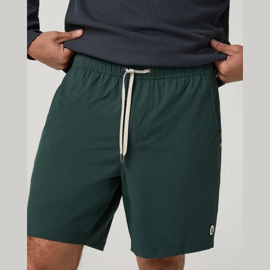 A close-up of a person wearing dark green Kore Short 7.5" – Men&