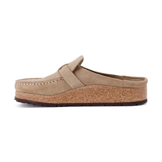 A single slip-on BIRKENSTOCK Buckley clog-style shoe in light tan suede with a cork-textured wedge midsole and dark outsole, shown in side profile on a white background.