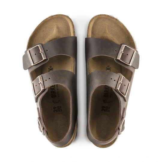 Pair of brown Birkenstock Milano Soft Footbed sandals with buckles on a white background