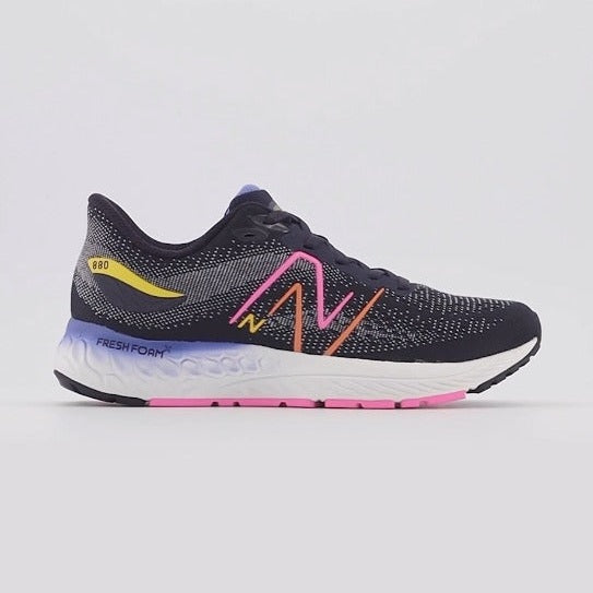 A New Balance Y 880 V12 – Kids' running shoe in black and gray with a white midsole, featuring a pink and orange 'N' logo, a yellow heel accent, and a purple and pink outsole, shown against a light gray background.