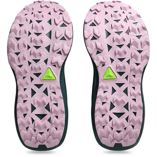 A Trabuco Max 4 pair of shoe soles shown from the bottom, featuring a light pink treaded outsole with a small bright green triangular logo in the center of each half and a dark green edge.
