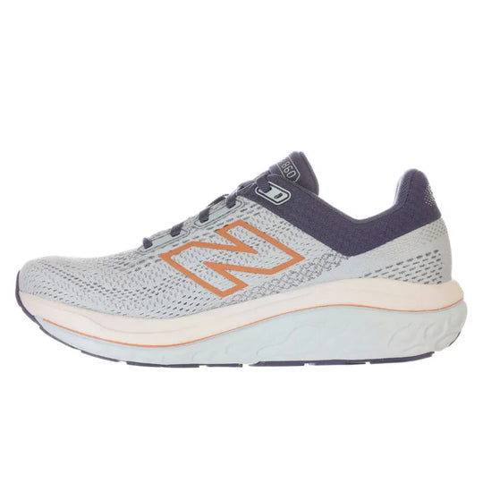 A New Balance 860 V14 running shoe in light gray mesh with a navy blue collar and heel, featuring a prominent orange &