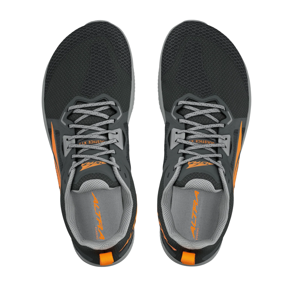 Solstice XT 3 a men's pair of athletic running shoes shown from a top-down view on a plain white background. The shoes are primarily dark gray with black mesh panels, gray laces, and bright orange accents on the sides and tongue.