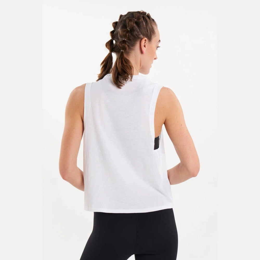Woman wearing Alwrld Alsprt Seacell Muscle Tank a white sleeveless top and black leggings on a white background