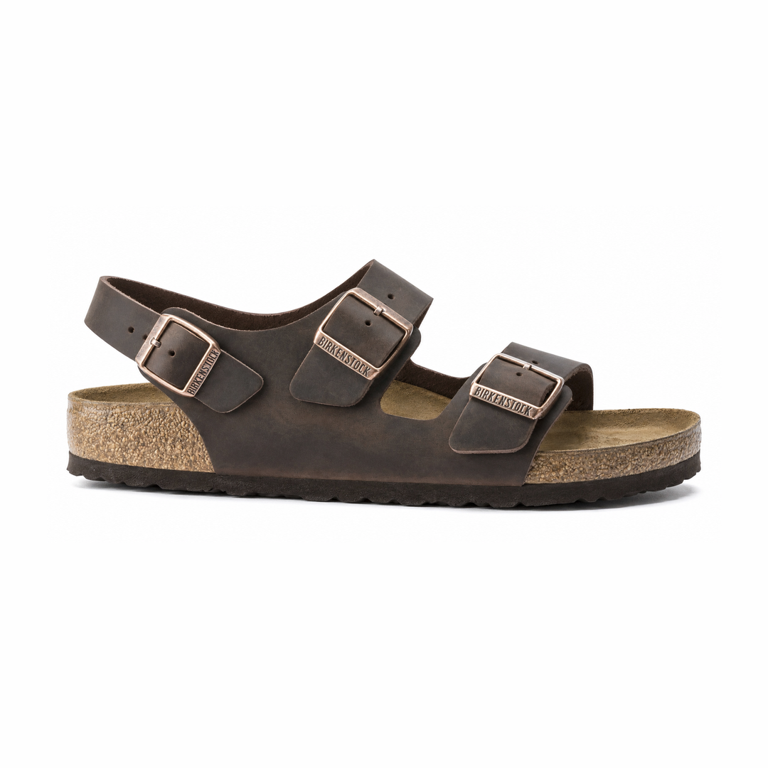 A dark brown Birkenstock Milano Soft Footbed leather double-strap sandal with adjustable buckles and a cork-look midsole, shown from a side profile on a white background.