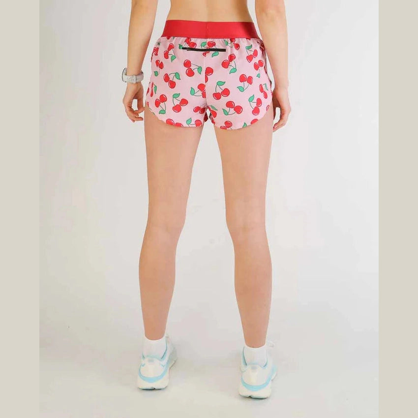 Person wearing pink Chicknlegs 1.5" Split Shorts – Women's with cherry pattern on a plain background