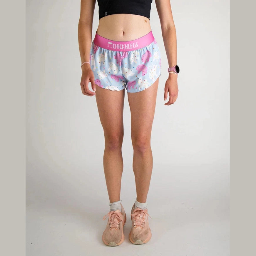 Person wearing light blue Chicknlegs 1.5" Split Shorts – Women's with pink waistband on a plain background