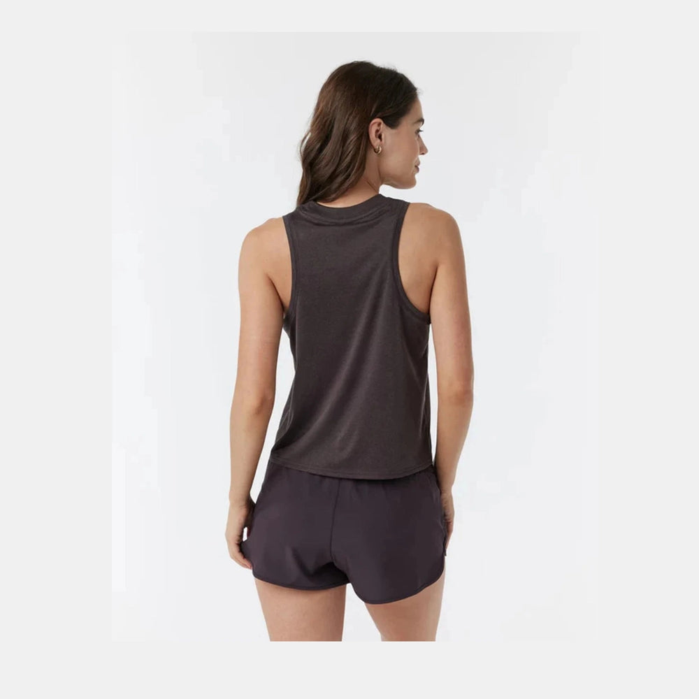 A woman shown from the back wearing a dark brown  Vuori Energy Top – Women's sleeveless athletic tank top and matching dark shorts against a light gray studio background.
