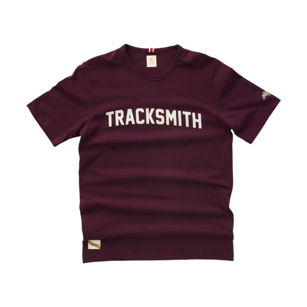 A maroon Grayboy Tee – Men's tee with 'TRACKSMITH' printed in white arched block letters across the chest, shown flat against a white background.