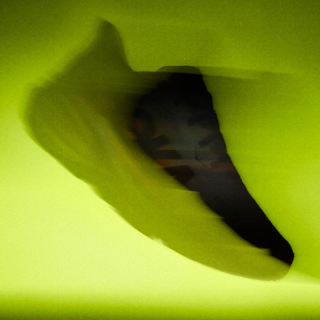 Hoka Clifton Pro running shoe on a bright green background with brand logo.