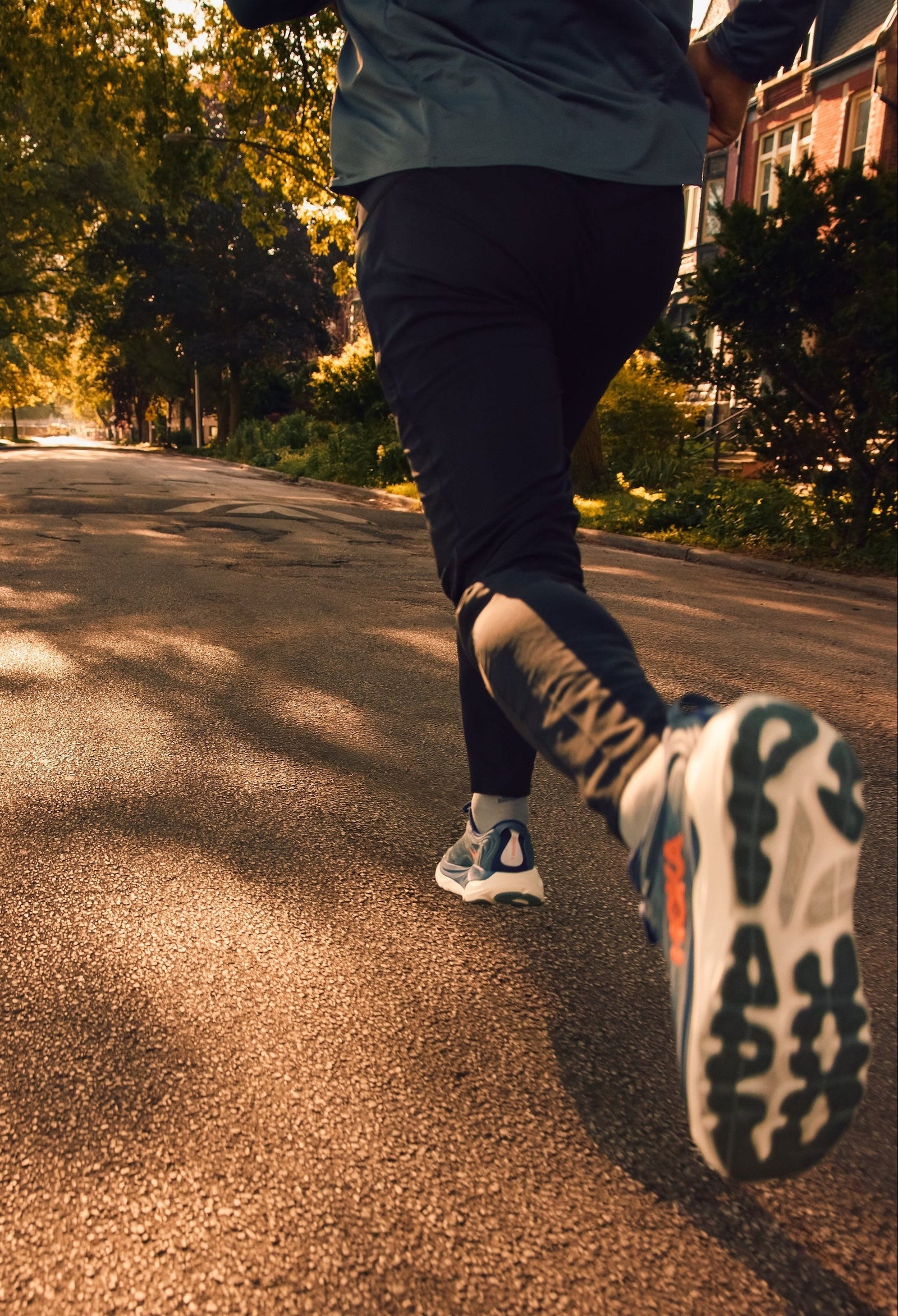 Person running in the Hoka mens Gaviota 6 running shoe on a road with trees and houses in the background