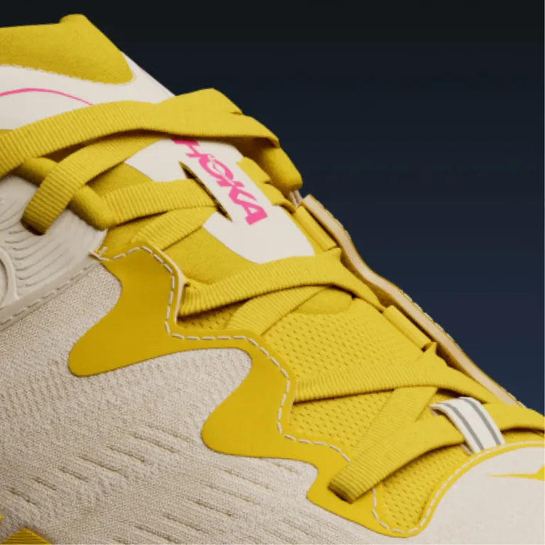 Close-up of a Hoka  Gaviota 6 sneaker with yellow laces and a visible brand logo on a dark background