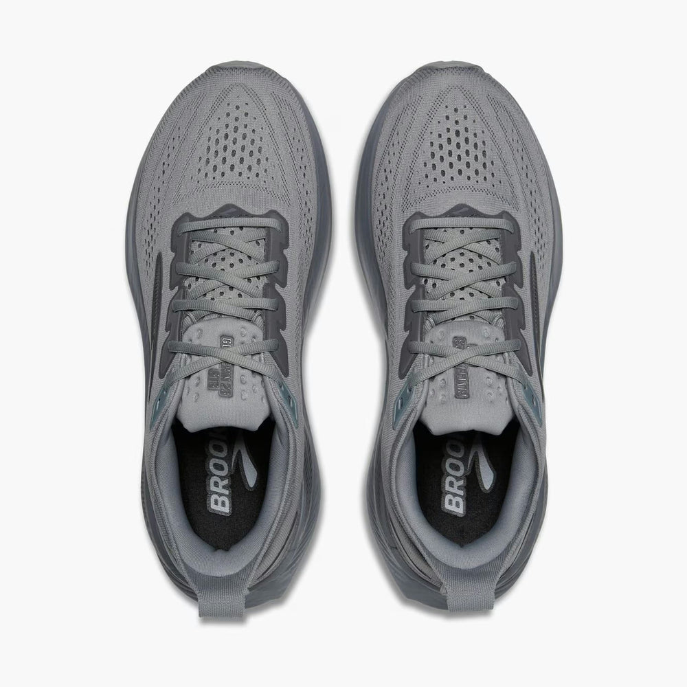 A pair of gray Brooks Glycerin GTS 23 – Men's athletic sneakers shown from a top-down view on a light gray background. The shoes feature a breathable mesh upper, gray laces, and the brand name 'BROOK' printed in white on the black insoles.