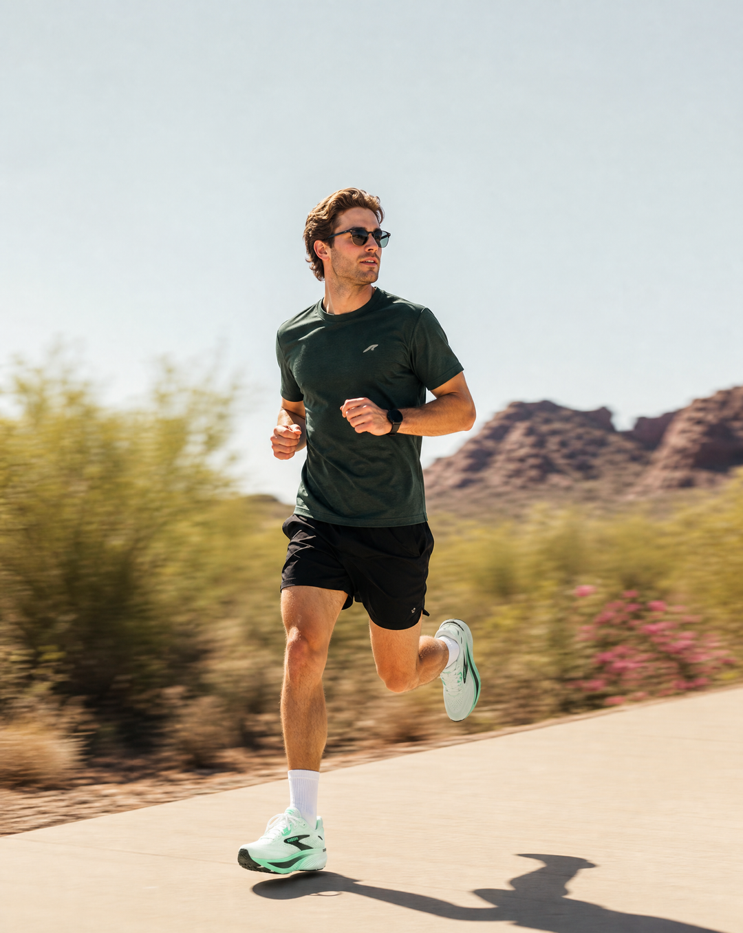 Man running in Brooks Ghost 18 on a path with desert landscape in the background