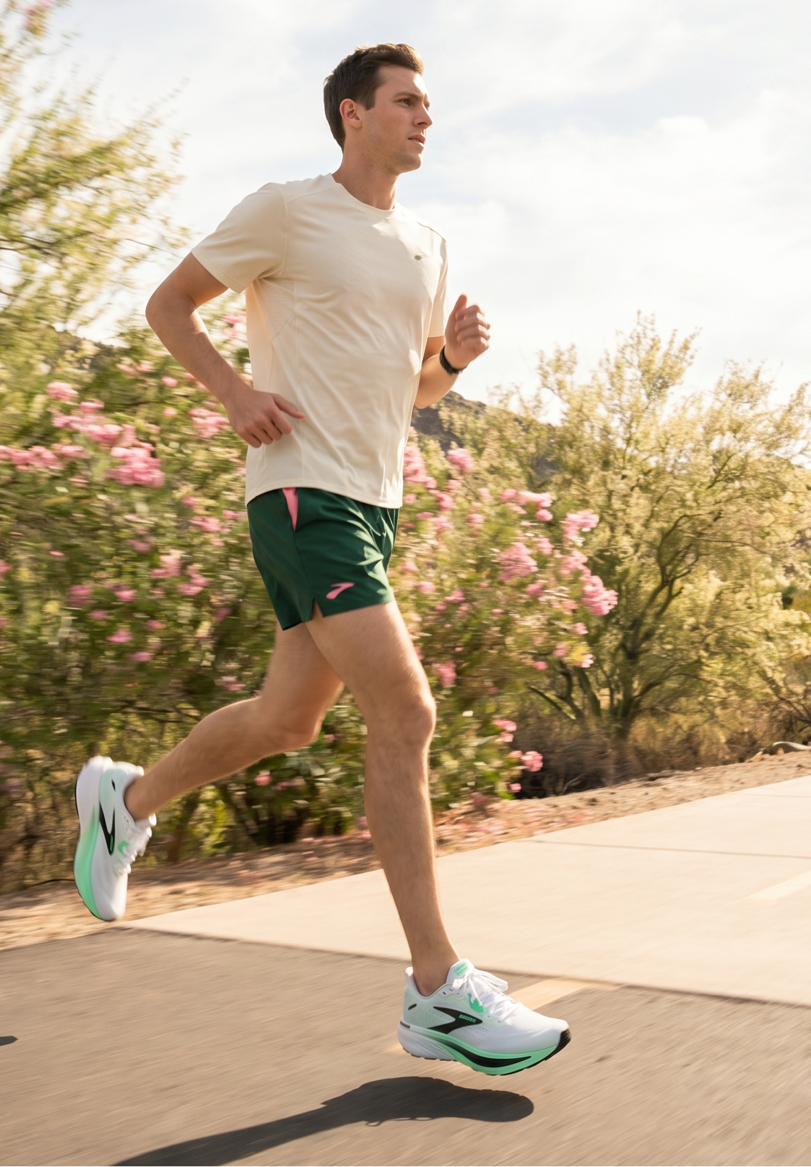 Man running on a path with trees and mountains in the background in the Brooks Ghost 18 shoes