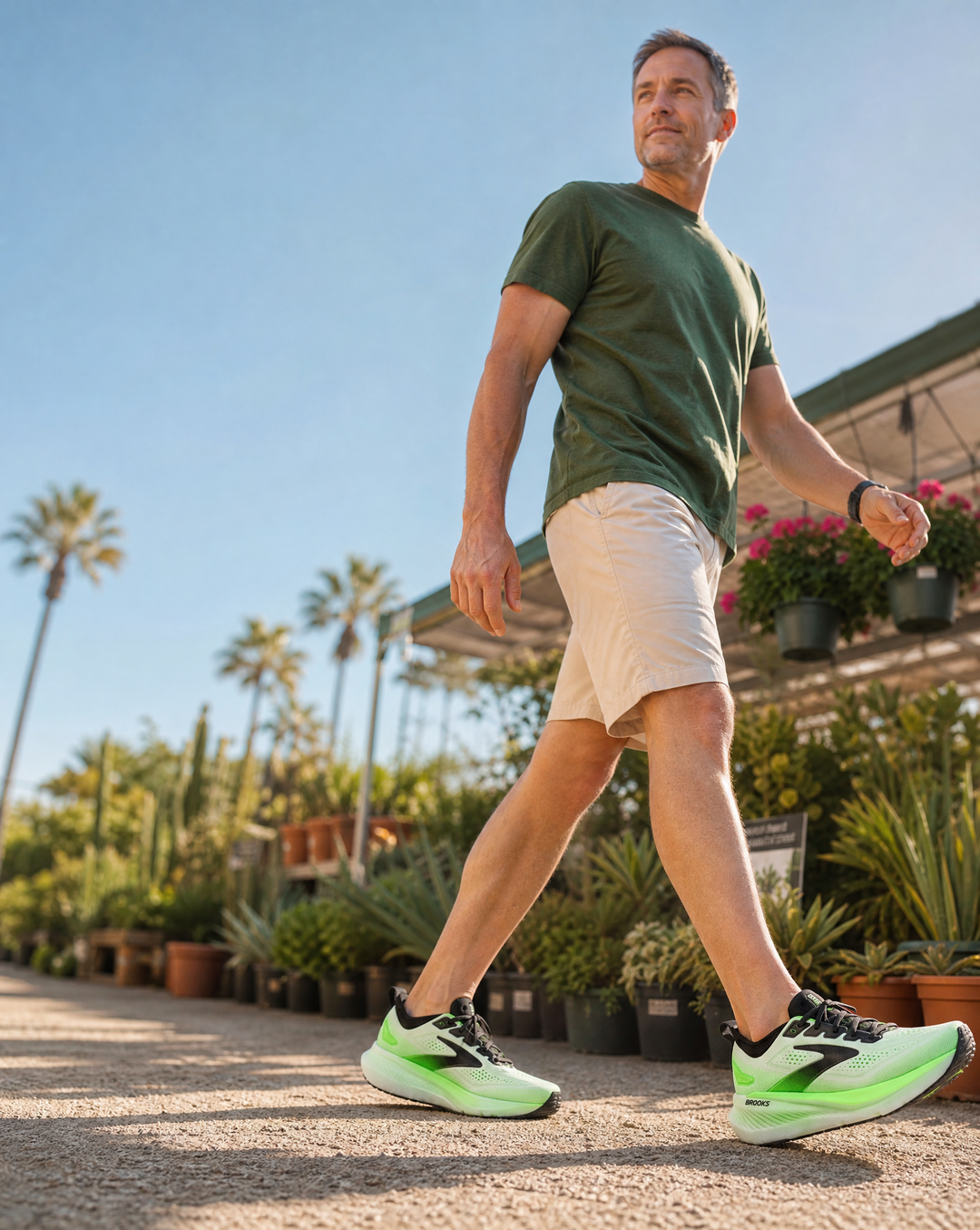 Man walking outdoors in Brooks Glycerin 23 in a garden with palm trees and plants.