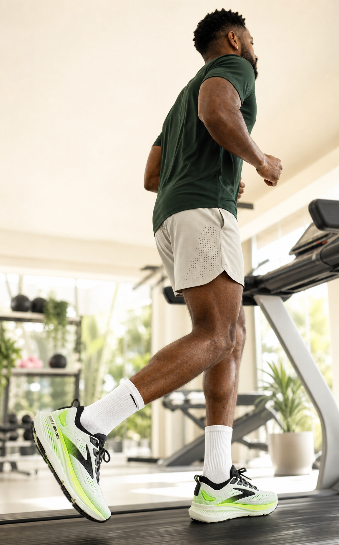 Man running on a treadmill in a home setting wearing Brooks Glycerin GTS 23