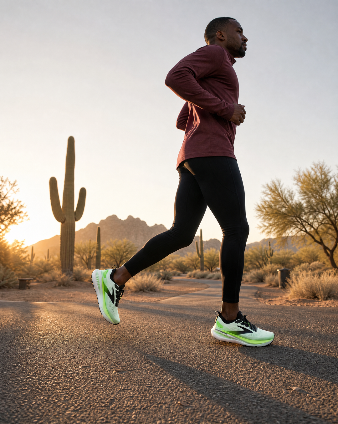 Person running on a desert path with cacti and mountains in the background wearing a Brooks Glycerin gts 23 running shoe