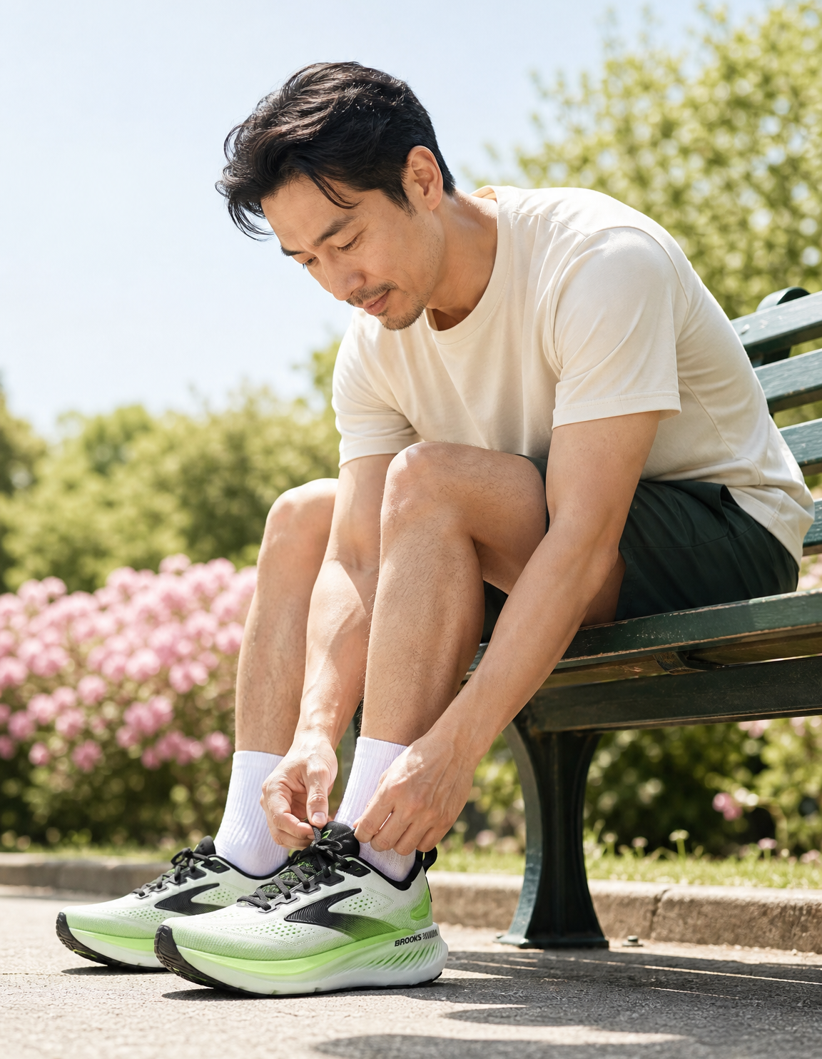 Man sitting on a bench tying his Brooks Glycering GTS 23 running shoes in a park.