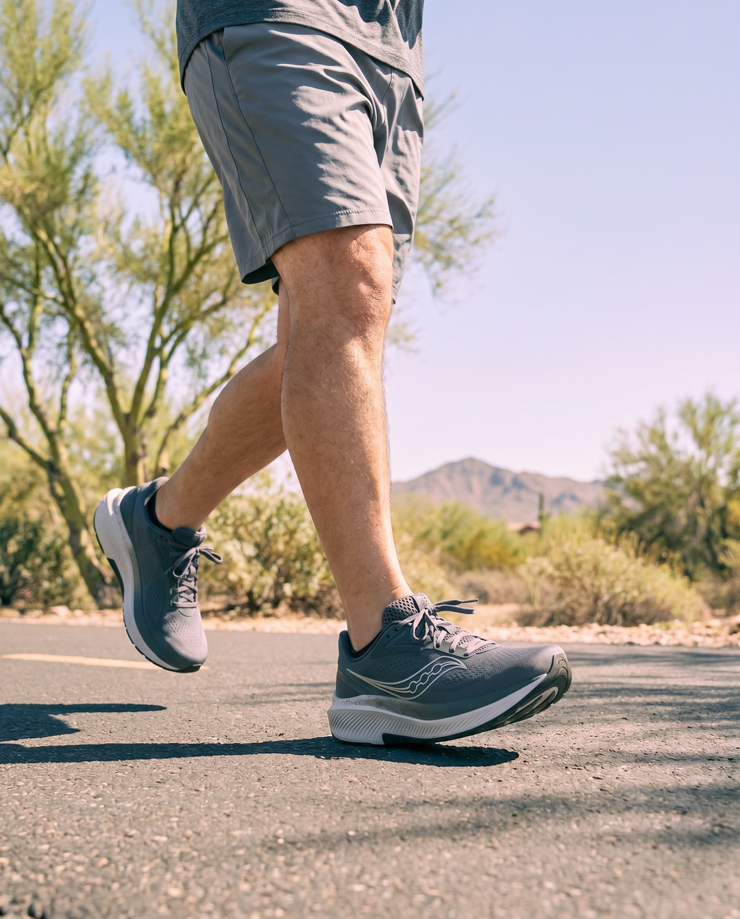 Person running on a road with a natural landscape in the background
