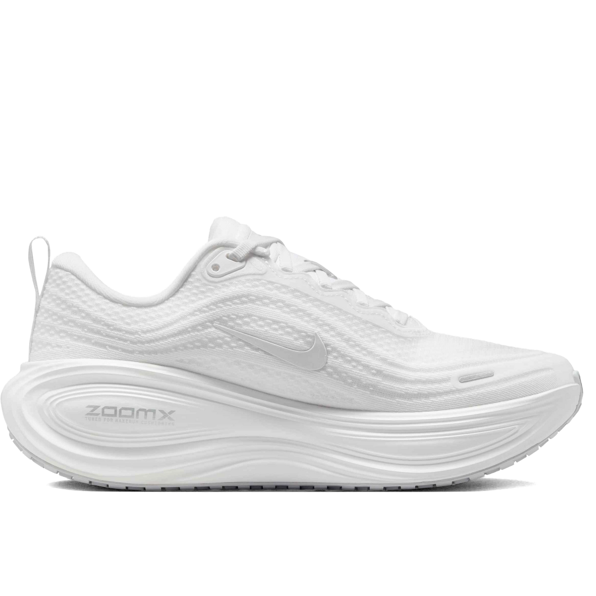 A white Nike Vomero Plus - Women's running shoe with a thick, cushioned white sole featuring the 'ZOOMX' text, shown from a side profile on a solid white background.