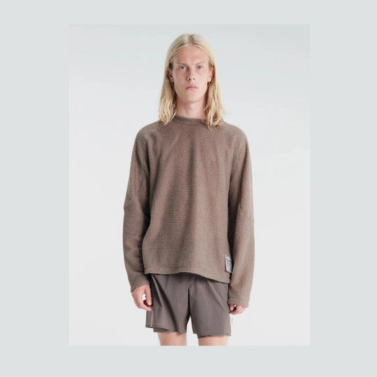 A model with long blonde hair wearing a textured, oversized brown knit Fuzz Fleece AD Long Tee--Men&