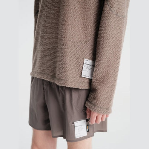 A close-up of a person wearing a textured taupe-brown Fuzz Fleece AD Long Tee--Men&