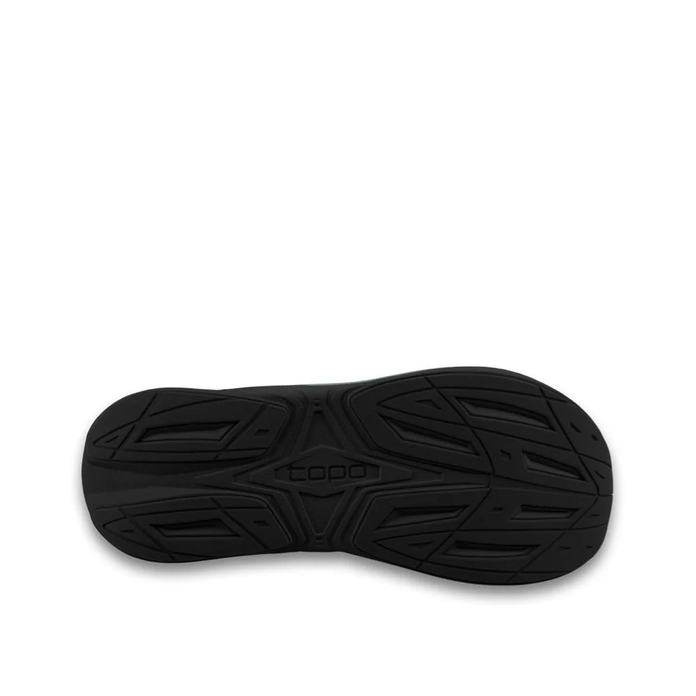 Black sandal with textured sole on a beige background