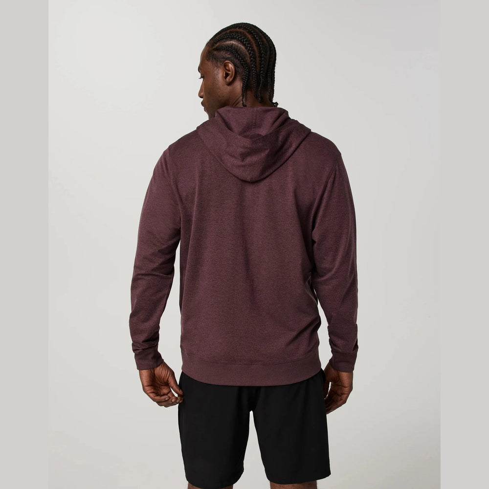 Person wearing a maroon hoodie and black shorts on a plain background