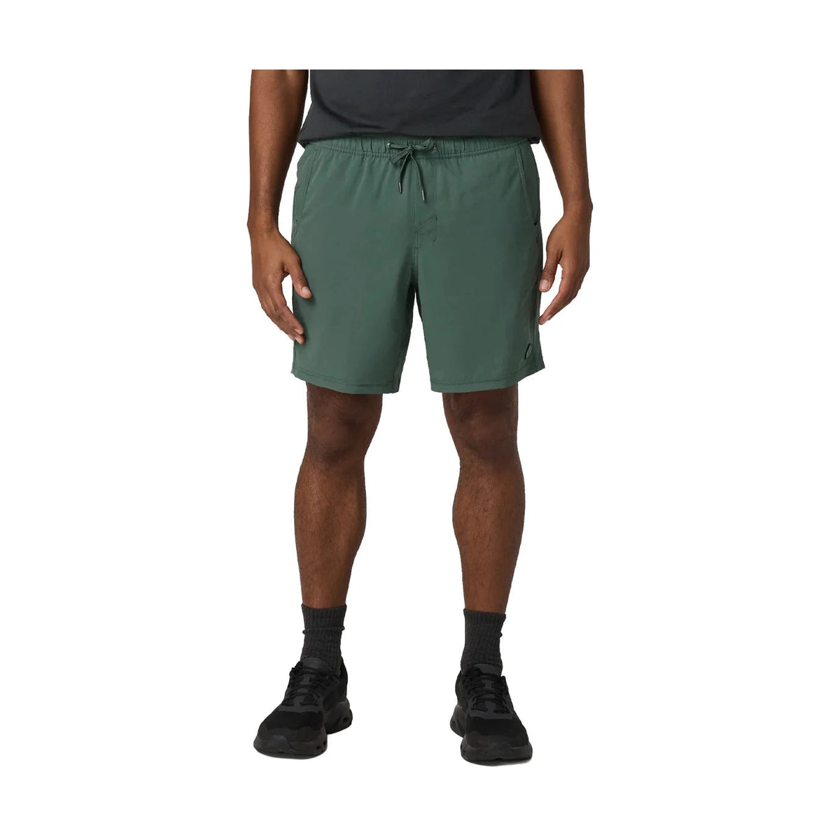 Person wearing green Vuori Kore Short 7.5" – Men's shorts on a white background