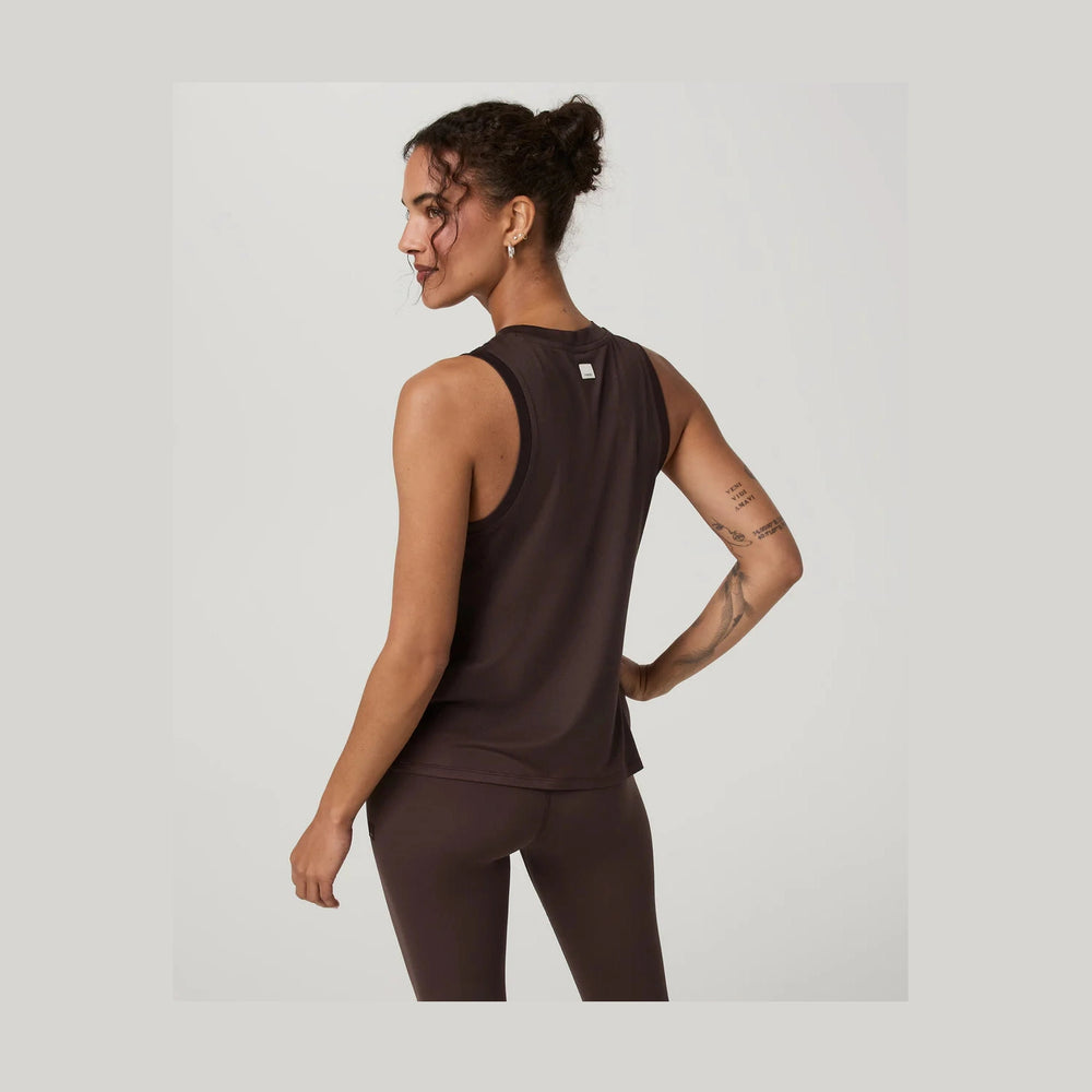 Woman wearing a brown Vuori Energy Top Long--Women's top and leggings on a light gray background