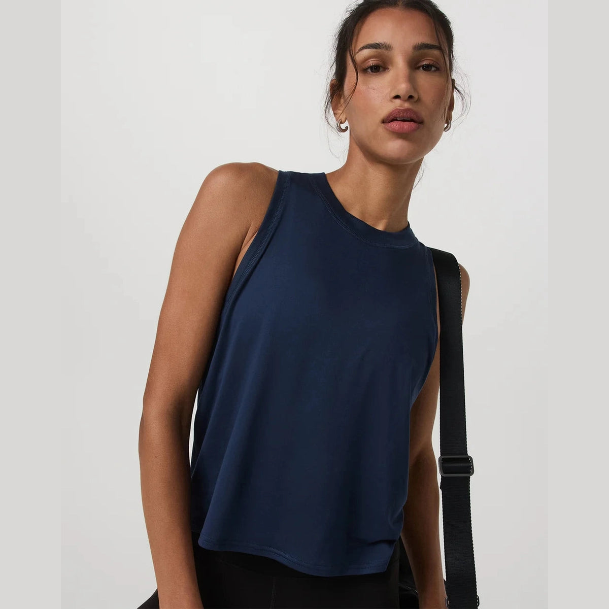 Woman wearing a navy blue Vuori Energy Top – Women's sleeveless top against a plain background