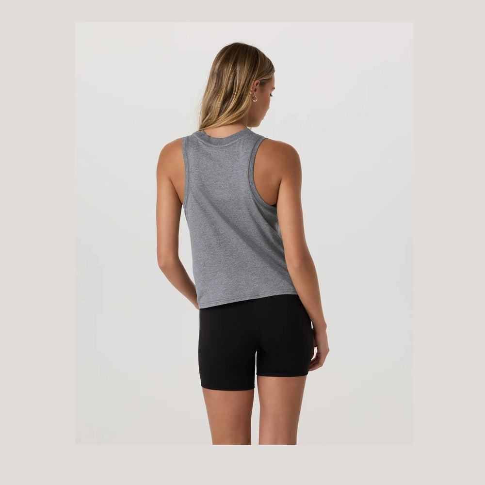 A woman shown from the back wearing a heather gray Vuori Energy Top – Women's sleeveless athletic tank top and black fitted shorts against a plain light gray studio background.