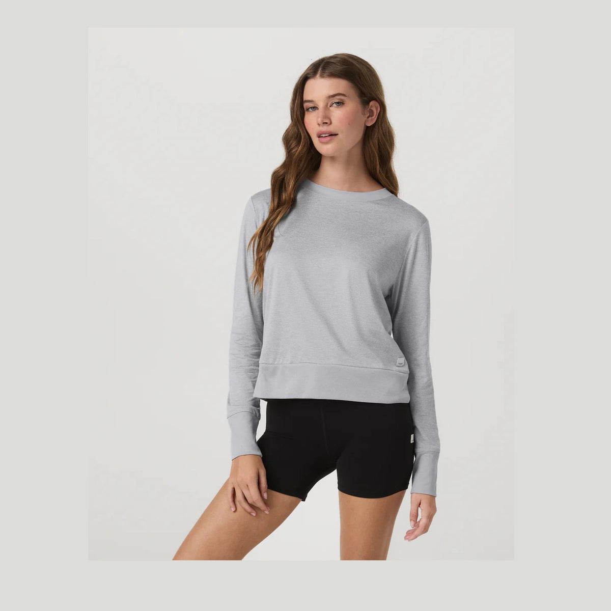 Woman wearing a gray Daydream Crew--Women's and black shorts on a light gray background