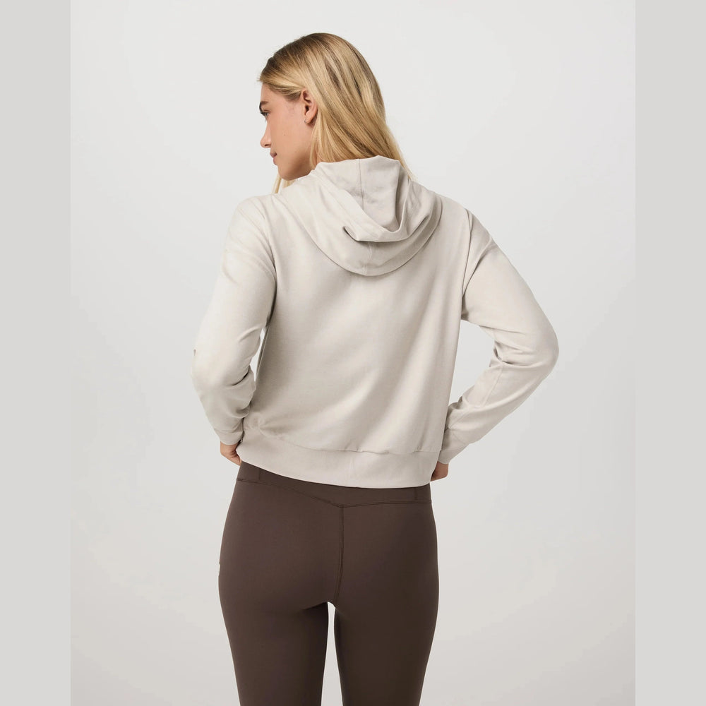 Person wearing a beige Halo Modern Full Zip Hoodie – Women's and brown leggings on a light gray background