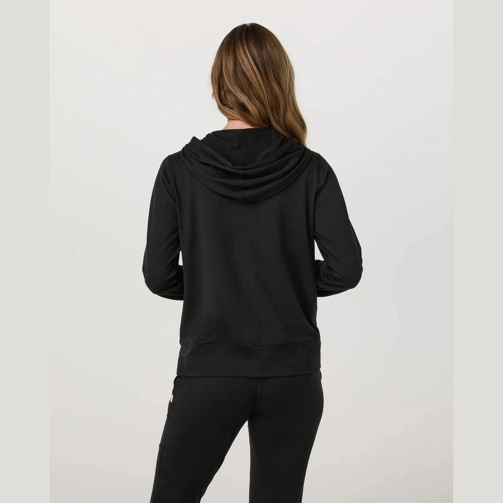 Person wearing a black Vuori Halo Perform Hoodie 2.0 – Women's hoodie and pants on a light gray background